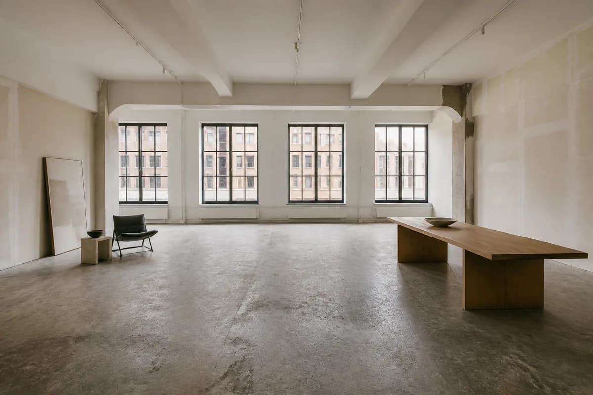 A raw Chelsea artist's loft with north-facing steel windows, patched plaster walls and a concrete floor