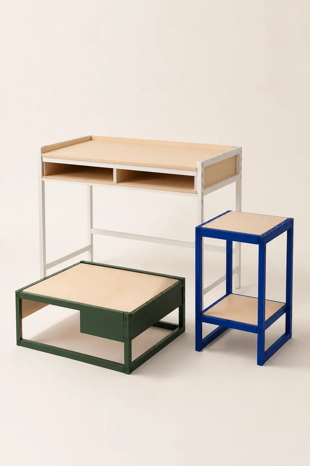 A birch desk, a deep green low table and a cobalt steel side table grouped in a studio