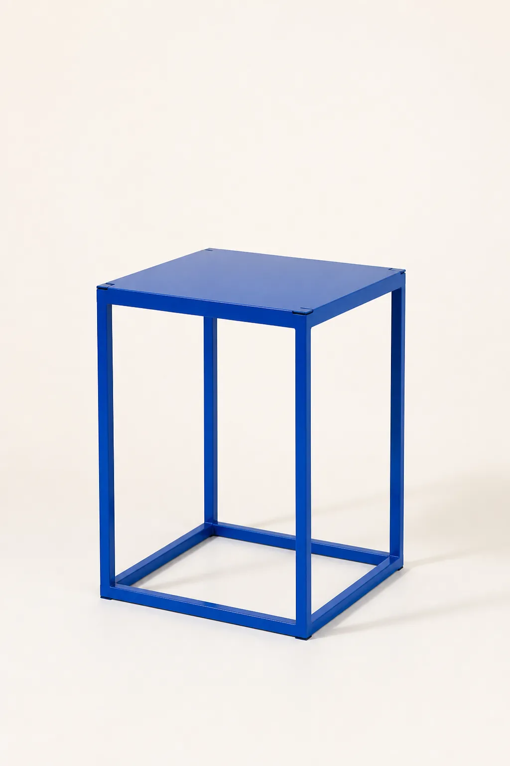 A small side table in cobalt blue powder-coated steel with a flat top
