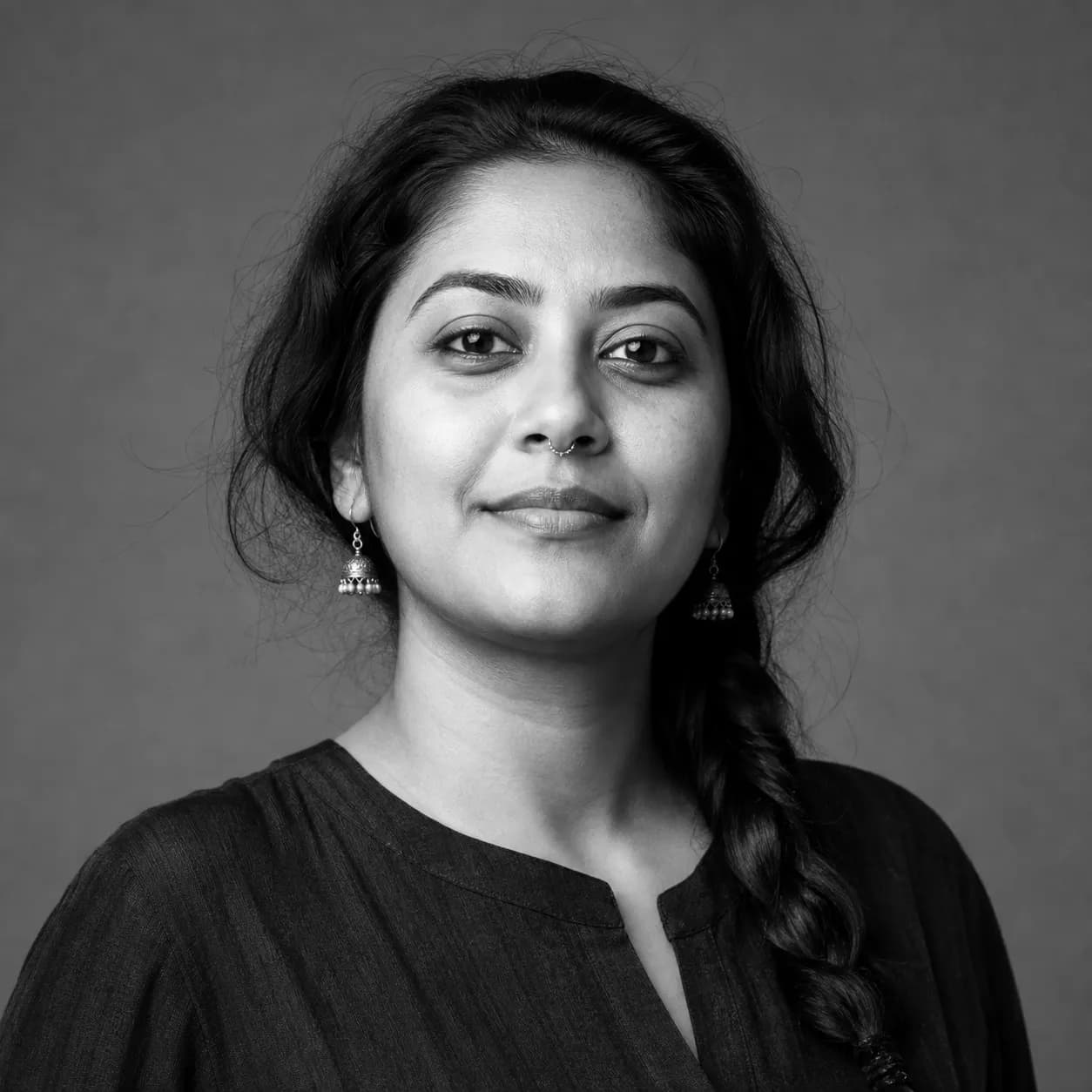 Black and white studio portrait of a presenter with a long braid