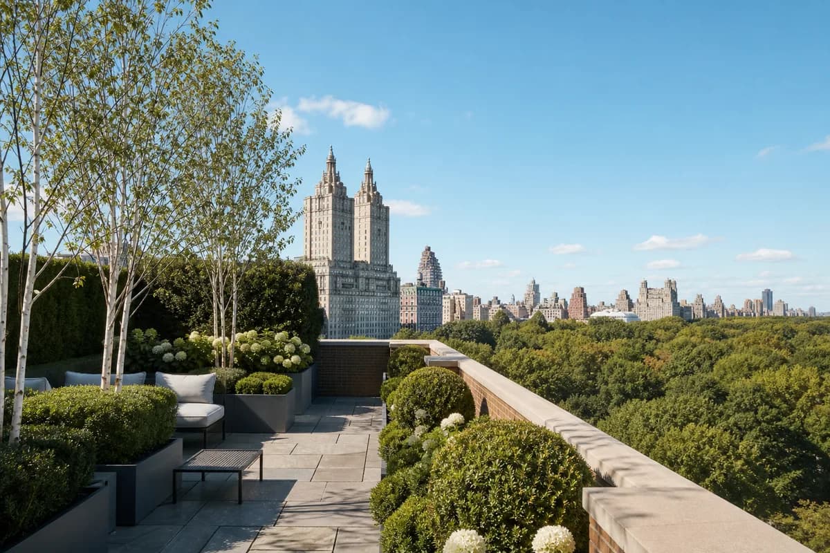 A Central Park West penthouse terrace with clipped boxwood and bluestone paving above the Central Park canopy